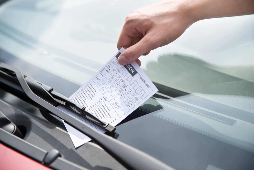 Vender carros com multas é possível? Entenda 8 Imagem de multa sendo colocada no parabrisa de veículo