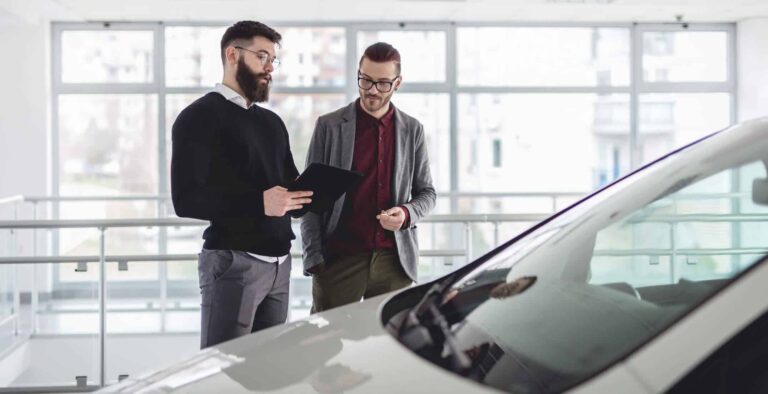 Imagem de dois homens negociando a venda de um carro