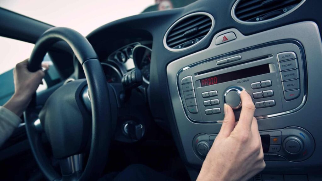 Som automotivo valoriza o carro na revenda? Depende do perfil do comprador 5 Mão de homem mexendo no volume do carro