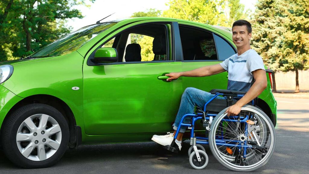 Carro PCD: Quem tem direito a adquirir esse custo-benefício? 2 Homem com cadeira de rodas prestes a entrar em um carro verde