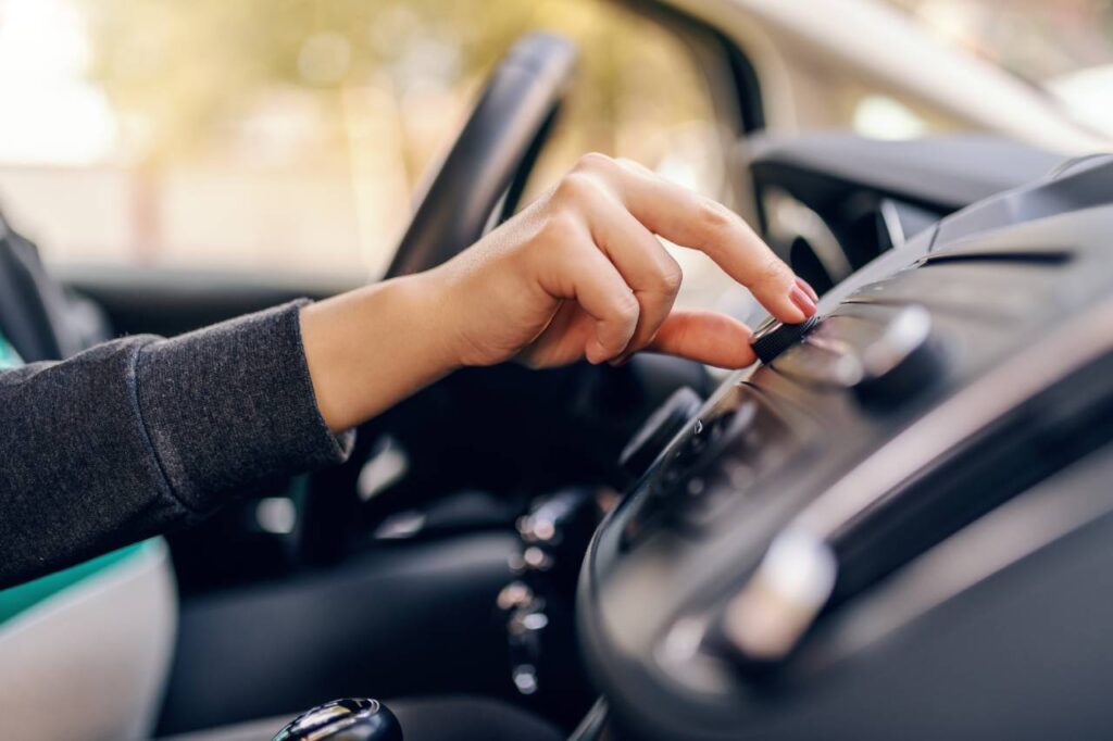 mão masculina aumentando o volume do som automotivo