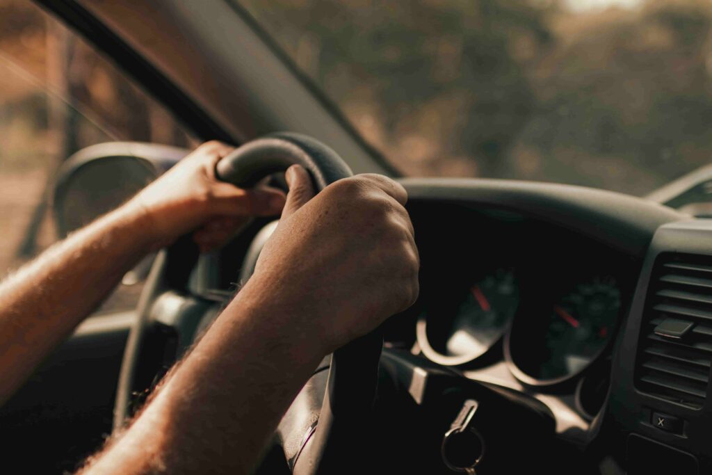 Imagem de uma pessoa com as mãos no volante.
