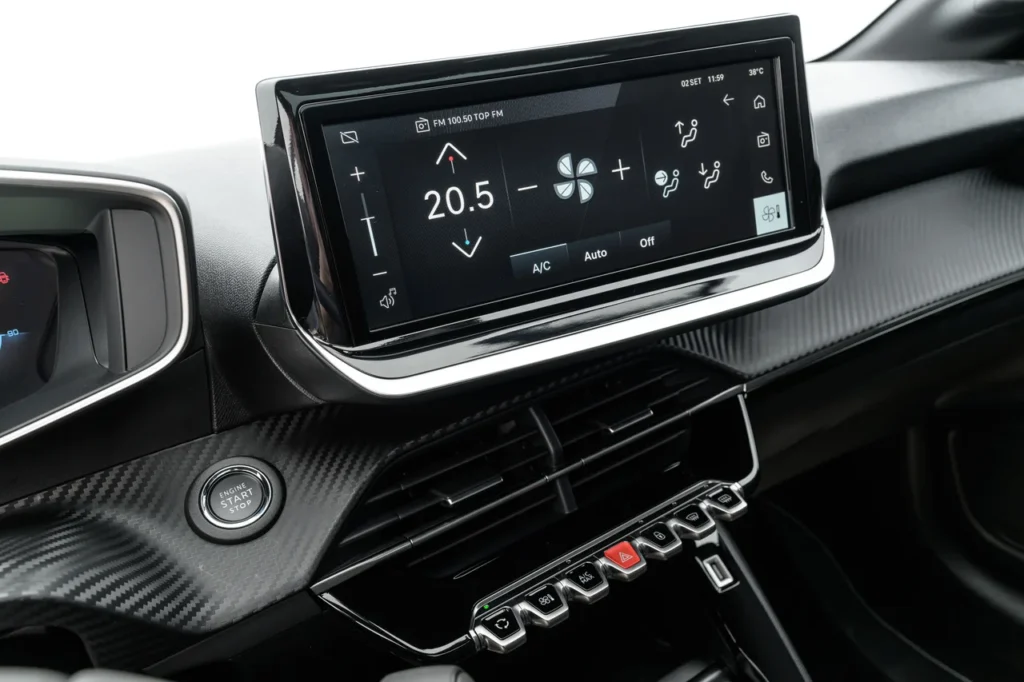Painel digital de um Peugeot 208 Turbo Style exibindo os controles do sistema de climatização, ilustrando como o uso do ar-condicionado aumenta o consumo de combustível